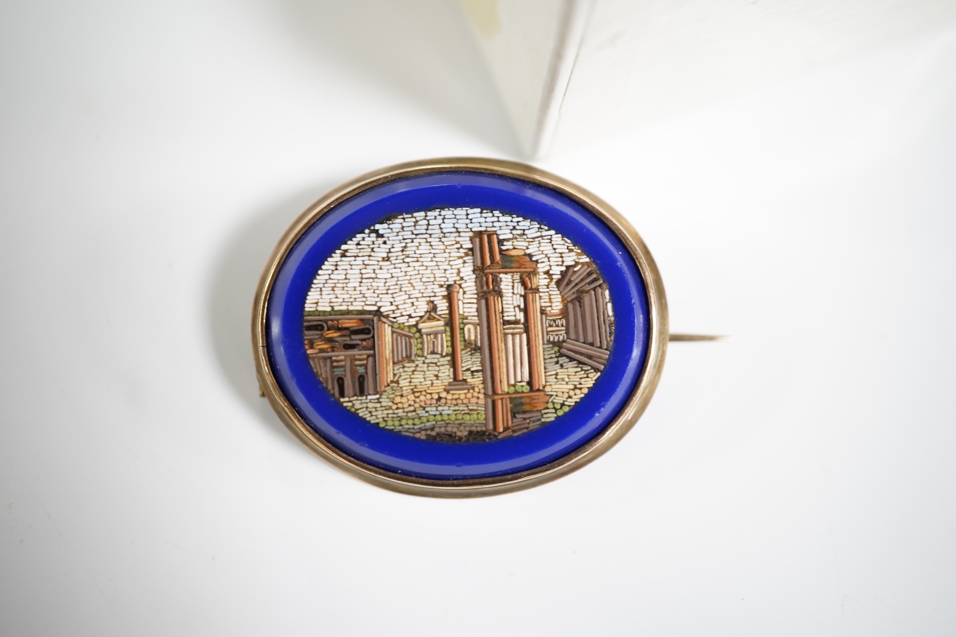 A micromosaic brooch and a group of bead necklaces, comprising: a micromosaic brooch depicting the Forum, length 4.6cm; together with a carnelian bead necklace; a coral branch necklace; and a green glass bead necklace
